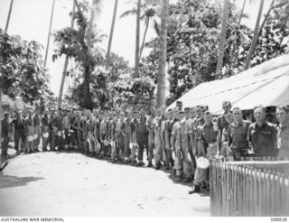 RABAUL, NEW BRITAIN. 1945-11-19. TROOPS ATTENDING A MESS PARADE AT 52 TRANSPORT PLATOON, AUSTRALIAN ARMY SERVICE CORPS CAMP, ON THE SHORE OF TALILI BAY