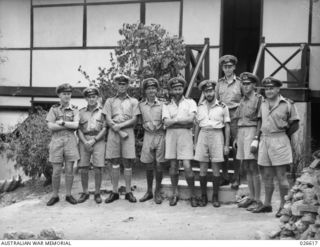 PORT MORESBY, PAPUA. 1942-09. COMMANDER R.B.A. HUNT RAN (CENTRE), NAVAL OFFICER IN COMMAND, PORT MORESBY, AND HIS STAFF OUTSIDE THEIR QUARTERS