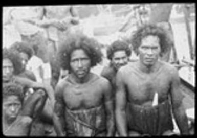 Group of men, and a boy; man on right has large earrings