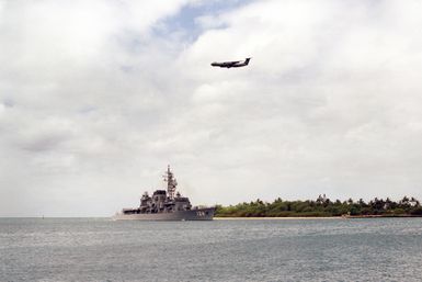 A starboard bow view of the Japanese destroyer MINEYUKI (DD 124) underway during Exercise RIMPAC '86. A C-141B Starlifter aircraft is passing overhead