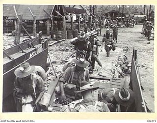 JACQUINOT BAY, NEW BRITAIN. 1945-09-09. TROOPS OF THE 4 INFANTRY BRIGADE BOARDING BARGES FOR TRANSPORTATION TO HMAS MANOORA. THE MANOORA CARRIED TROOPS FOR THE OCCUPATION OF THE RABAUL AREA, ..