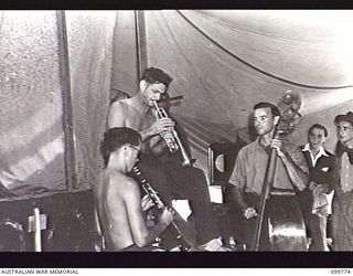 TOROKINA, BOUGAINVILLE, 1945-11-03. MEMBERS OF THE ORCHESTRA OF THE KOOKAROOS CONCERT PARTY, AUSTRALIAN ARMY AMENITIES SERVICE, TRYING OUT A NEW NUMBER IN PREPARATION FOR THE NIGHT'S SHOW. ..