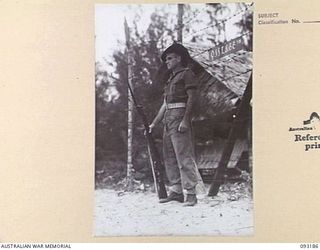 BOUGAINVILLE, 1945-06-18. PTE T. KUMBLE, 9 INFANTRY BATTALION, STANDING GUARD AT ENTRANCE TO THE AUSTRALIAN ARMY NURSING SERVICE QUARTERS, 109 CASUALTY CLEARING STATION, MOTUPENA POINT