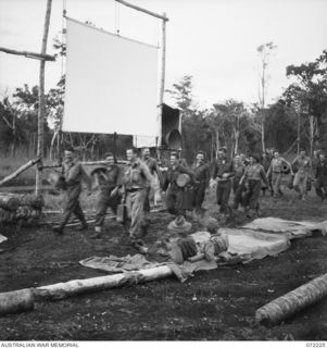 KILIGIA, NEW GUINEA. 1944-04-10. AN HOUR AND A HALF BEFORE THE SCREENING OF THE FILM "CHARLEY'S AUNT", AT HEADQUARTERS 5TH DIVISION AREA TROOPS ARRIVE WITH AN ASSORTMENT OF SEATS