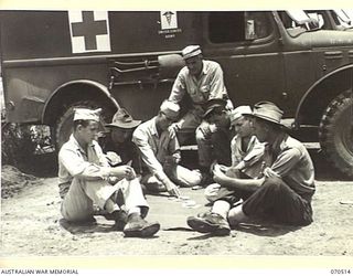 WARD'S DROME, PORT MORESBY, PAPUA, 1944-02. AUSTRALIAN AND AMERICAN AMBULANCE DRIVERS PLAYING CARDS WHILE AWAITING THE ARRIVAL OF CASUALTIES AT WARD'S DROME. THEY MEET THE PLANES IN ROTATION ..