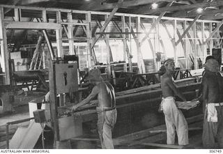 Members of the Japanese War Criminals Saw Mill Party in a large workshop preparing timber for the construction of the new store house being built at the RAN War Criminal Compound at an RAN shore ..