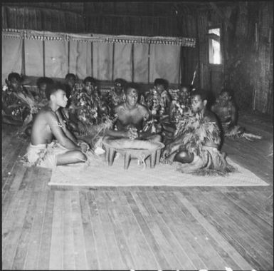 Yaqona ceremony by group of Fijian men, dressed in traditional costumes, in a grass hut, Nasalai, Fiji, 1966, 2 / Michael Terry