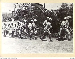 OCEAN ISLAND. 1945-10-02. FOLLOWING THE SURRENDER OF THE JAPANESE TROOPS OF 31/51 INFANTRY BATTALION OCCUPIED THE ISLAND. SHOWN, A JAPANESE WORKING PARTY RETURNING FROM THE BOAT HARBOUR WHERE THEY ..