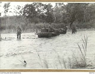 RAMU VALLEY, NEW GUINEA. 1943-11-26. A LIGHT 25 POUNDER GUN OF NO. 8 BATTERY, 2/4TH. AUSTRALIAN FIELD REGIMENT BEING HAULED ACROSS THE EVAPIA RIVER IN THE KESAWAI AREA