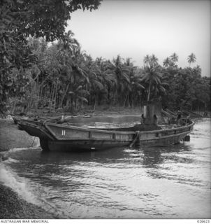 MILNE BAY, PAPUA. 1942-09. TYPE OF DENSE JUNGLE FORESHORE THAT JAPANESE LANDED THEIR BARGES ON IN THEIR UNSUCCESSFUL ATTEMPT AT LANDING AT MILNE BAY. WRECKED BARGE IN FOREGROUND