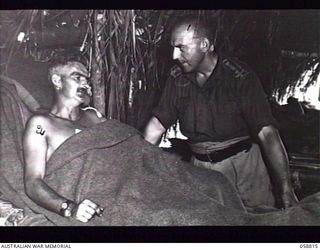 DUMPU, NEW GUINEA. 1943-10-15. SX1476 SENIOR CHAPLAIN D. L. REDDING, PADRE OF THE 7TH AUSTRALIAN DIVISION CHATTING TO SX10955 CORPORAL G. M. C. MCPHEE OF THE 2/27TH AUSTRALIAN INFANTRY BATTALION, ..