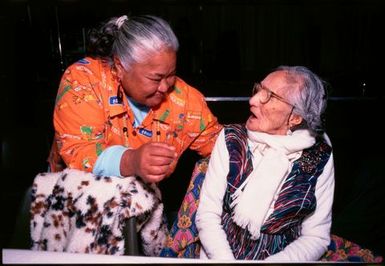 Two women conversing at Niuean ear-piercing ceremony, Auckland