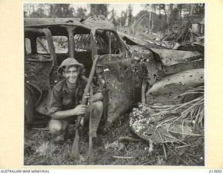 1942-12-16. PAPUA. FALL OF GONA. THIS JAPANESE STAFF CAR WAS FOUND IN THE MIDDLE OF GONA VILLAGE. IT WAS COMPLETELY WRECKED BY MACHINE-GUN AND RIFLE FIRE. THE CAR WAS PORTION OF THE EQUIPMENT ..