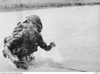 1943-10-21. NEW GUINEA. RAMU VALLEY. PTE. S. WARNE OF PORT PIRIE, S.A., GOT A DUCKING WHILE CROSSING THE SURINAM RIVER. (NEGATIVE BY G. SHORT)