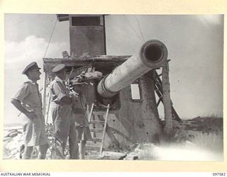 TARAWA ISLAND, GILBERT AND ELLICE ISLAND GROUP. 1945-09-27. RESIDENT COMMISSIONER, COLONEL V. FOX-STRANGWAYS SHOWS BRIGADIER J.T. STEVENSON AND LIEUTENANT COMMANDER M. ROSE ONE OF THE 8" NAVAL GUNS ..
