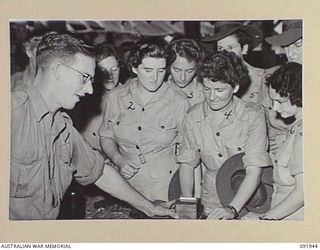 LAE, NEW GUINEA, 1945-05-18. PERSONNEL FROM THE AUSTRALIAN WOMEN'S ARMY SERVICE BARRACKS, TAKING PART IN A CONDUCTED TOUR OF THE AREA ARRANGED BY ARMY AMENITIES SERVICE, ARE BEING SHOWN AN ORIGINAL ..