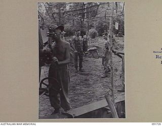 HAWAIN, WEWAK AREA, NEW GUINEA. 1945-05-09. LOADING MEMBERS OF 2/3 FIELD REGIMENT GUN CREW CARRYING A 95-LB SHELL ON LOADING TRAY TO A "LONG TOM" 155 MM GUN DURING THE ATTACK AGAINST THE MAIN ..