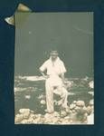 Don Honeysett standing on stones next to river, New Guinea, c1929 to 1932