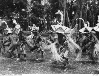 SONG RIVER, FINSCHHAFEN AREA, NEW GUINEA. 1944-03-26. FINSCHHAFEN BOYS PERFORMING THEIR SIASSI DANCE DURING A SING-SING IN THE AUSTRALIAN NEW GUINEA ADMINISTRATIVE UNIT COMPOUND, HELD TO CELEBRATE ..