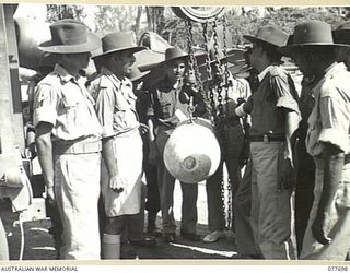 TOROKINA, BOUGAINVILLE ISLAND. 1944-12-23. TROOPS OF THE 1ST INDIAN HEAVY ANTI-AIRCRAFT REGIMENT SHOWING A KEEN INTEREST IN THE BOMB LOADING OPERATIONS BEING CARRIED OUT BY MEMBERS OF THE ROYAL NEW ..