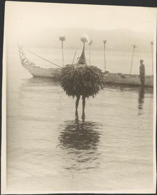 Dukduk walking ashore from a canoe, Rabaul, New Guinea, ca. 1929 / Sarah Chinnery