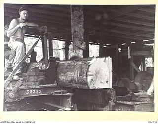 YALU AREA, NEW GUINEA, 1945-07-30. THE CANADIAN BREAKING DOWN SAW AT NO. 2 PLATOON SAWMILL, 2/1 FORESTRY COMPANY, ROYAL AUSTRALIAN ENGINEERS, PHOTOGRAPHED AT THE REQUEST OF THE COMMANDING OFFICER