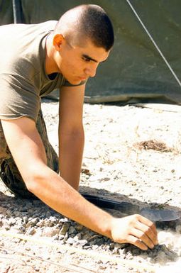 US Marine Corps (USMC) Private First Class (PFC) Zaroga, Eco Company, 2nd Battalion, 3rd Marine Regiment (2/3), Marine Corps Base Hawaii (MCBH), Hawaii (HI), places rocks along the outer border of a terrain model at CROCODILE 2003