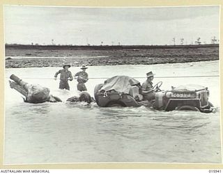 1943-10-07. NEW GUINEA. MARKHAM VALLEY ADVANCE. EQUIPMENT BEING TAKEN ACROSS THE 18 KNOT UMI RIVER. (NEGATIVE BY MILITARY HISTORY NEGATIVES & GORDON SHORT)