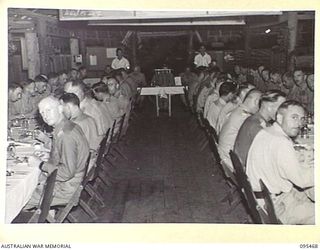 LAE AREA, NEW GUINEA, 1945-08-25. ORDNANCE OFFICERS SEATED AT TABLES IN THE OFFICERS' MESS, 4 ADVANCED ORDNANCE DEPOT, AUSTRALIAN ARMY ORDNANCE CORPS DURING THEIR VICTORY DINNER