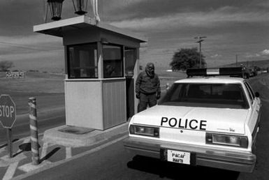 A security police guard from the 15th Air Base Wing, wears a full chemical warfare outfit while on duty at the rear gate
