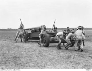 LYTTON, QLD. 1943-11-11. GUN DRILL AT T AUSTRALIAN HEAVY BATTERY, 155MM. EQUIPMENT. PERSONNEL ARE TRAINED HERE TO TAKE OVER FORTRESS AREAS IN NEW GUINEA. SHOWN ARE: GUNNER A. J. COLTMAN (1); ..