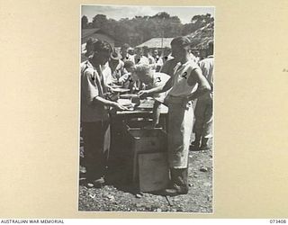 LAE, NEW GUINEA. 1944-05-24. WALKING PATIENTS AT THE 2/7TH GENERAL HOSPITAL FILING PAST MESS ORDERLIES DURING A MESS PARADE. THE PARADE IS ATTENDED BY ALL WALKING PATIENTS AT THE HOSPITAL. ..