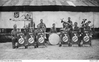 Group portrait of musicians in the 36th Battalion, Australian Military Forces (AMF), swing band outside the hut shared by the Australian Comforts Fund (ACF) and Salvation Army. In 1944 the ..