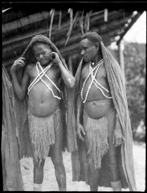 Two Kukukuku men wearing long bark rain hoods with one scratching his ear, Salamaua, New Guinea, 1933, 2 / Sarah Chinnery