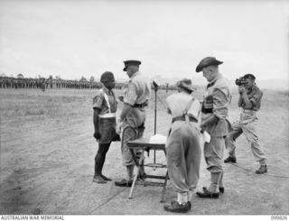 RABAUL, NEW BRITAIN, 1946-02-14. MAJOR GENERAL K.W. EATHER, GENERAL OFFICER COMMANDING 11 DIVISION, PRESENTING THE MILITARY MEDAL TO WARRANT OFFICER 2 BENGARI, 1 NEW GUINEA INFANTRY BATTALION, ..