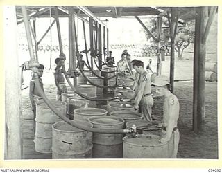 PORT MORESBY, NEW GUINEA. 1944-06-27. TROOPS OF THE 1ST BULK PETROLEUM STORAGE COMPANY WORKING ON THE DISTILLATE DRUM FILLING PLATFORM. IDENTIFIED PERSONNEL ARE:- NX141706 PRIVATE D. MITCHELL (1); ..