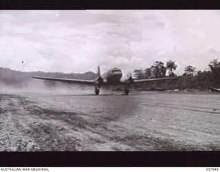 LAE, NEW GUINEA. 1943-10-04. A DOUGLAS TRANSPORT AIRCRAFT TAKING OFF FROM THE AIRSTRIP AFTER LANDING SUPPLIES OF RATIONS AND EQUIPMENT FOR FIGHTING TROOPS. THIS STRIP WAS CAPTURED ON THE 16TH ..