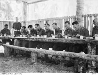 SIAR, NEW GUINEA. 1944-06-20. OFFICERS OF THE 58/59TH INFANTRY BATTALION EATING LUNCH IN THE OFFICER'S MESS. IDENTIFIED PERSONNEL ARE:- B3/195 MR. A.E. GREENE, YOUNG MEN'S CHRISTIAN ASSOCIATION ..