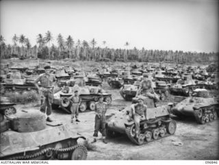 RAPOPO AIRSTRIP, NEW BRITAIN, 1945-09-19. JAPANESE MEDIUM AND LIGHT TANKS AND ARMOURED CARS LINED UP ON THE AIRSTRIP. MEMBERS OF 2/4 ARMOURED REGIMENT ARE PICTURED AMONGST THE TANKS