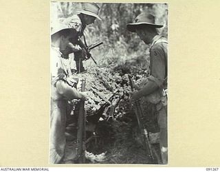 KALIMBOA, AITAPE-WEWAK SECTOR, NEW GUINEA. 1945-04-26. MEMBERS OF 2/3 INFANTRY BATTALION EXAMINING A JAPANESE PILLBOX WHICH HAD BEEN KNOCKED OUT BY A 2/4 ARMOURED REGIMENT MATILDA TANK. IDENTIFIED ..