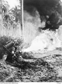 New Guinea. 1945. In the Aitape area, Lieutenant Brian Moloney of Kalgoorlie, WA, demonstrates the terrific heat and fire generated by a flame thrower at close range
