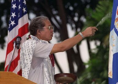 The Reverend Kahu Rinehardt throws rice to offer a Hawaiian blessing for the completed 15.3 million dollar renovation of the building housing the 15th Medical Group of the 15th Air Base Wing