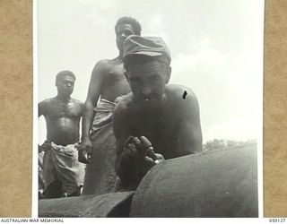 HANABADA, NEW GUINEA, 1943-10-23. VX79643 SAPPER J. REID OF THE 14TH AUSTRALIAN FIELD COMPANY, ROYAL AUSTRALIAN ENGINEERS, PREPARING A NEW PIPE JOINT ON THE NEW PIPELINE. THIS PIPELINE WILL CARRY ..