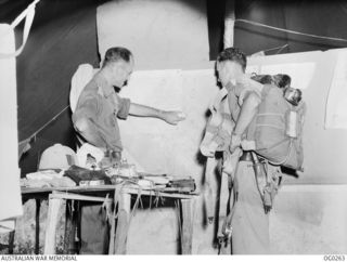 TSILI TSILI, NEW GUINEA. C. 1943-11. THE AIR LIAISON OFFICER WITH NO. 4 (ARMY COOPERATION) SQUADRON RAAF SHOWING FLYING OFFICER A. MILLER-RANDLE OF ADELAIDE, SA, WHERE THE AIF WANT SUPPLIES OF FOOD ..