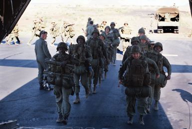 Troops of the 25th Battalion embark a C-130 Hercules aircraft for a joint air attack team training mission