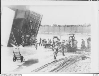 1943-09-29. NEW GUINEA. ATTACK ON FINSCHHAFEN. EQUIPMENT GOES ASHORE AT THE LANDING POINT SIX MILES FROM FINSCHHAFEN