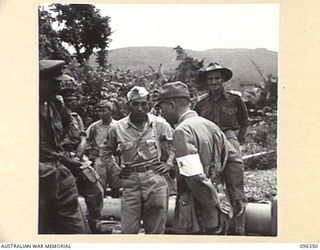 MUSCHU ISLAND, NEW GUINEA, 1945-09-08. MAJOR T FOGARTY, G2, 6 DIVISION AND TECHNICAL SERGEANT E.K. OKAZAKI, THE AMERICAN BORN JAPANESE INTERPRETER, DISCUSSING WITH CAPTAIN NOTO, JAPANESE STAFF ..