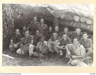 SORAKEN, BOUGAINVILLE. 1945-06-05. THE STAFF OF E TROOP, 12 BATTERY, 4 FIELD REGIMENT OUTSIDE THEIR LOG COMMAND POST. (FOR IDENTIFICATION OF 15 NAMED PERSONNEL REFER PROVISIONAL CAPTION OR NAME ..