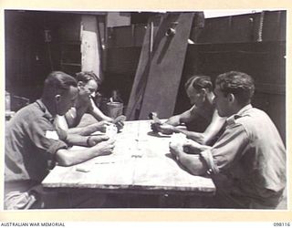 BORAM, NEW GUINEA. 1945-10-19. MEMBERS OF 43 LANDING CRAFT COMPANY PLAYING CARDS ABOARD THEIR BARGE. IDENTIFIED PERSONNEL ARE:- STAFF SERGEANT G. THOMPSON (1); PRIVATE E.W. JAMES (2); PRIVATE G. ..