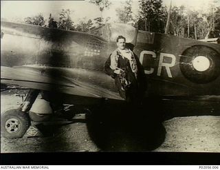 Morotai, New Guinea. 1945. Portrait of Group Captain Clive (Killer) Robertson Caldwell, DFC and Bar, DSO, No. 80 Fighter Wing RAAF, standing next to his Spitfire Mk VIIIC aircraft. The aircraft has ..